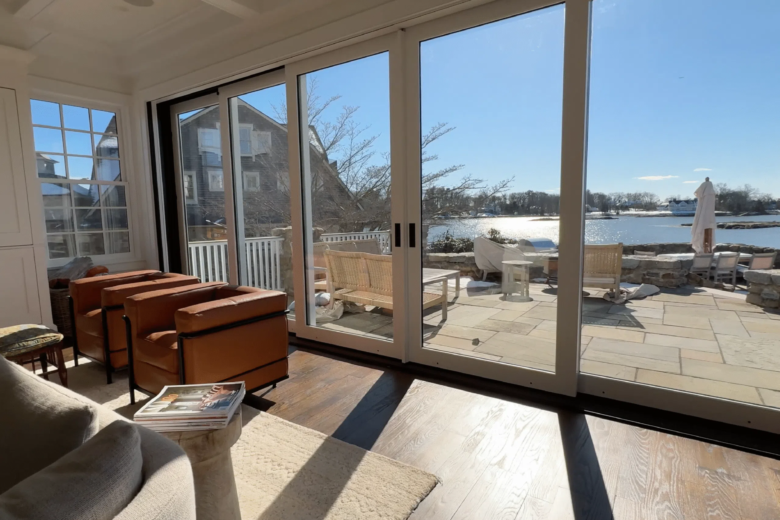Living room with leather chairs and a view of a deck and waterfront